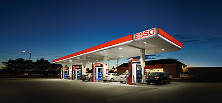 En Esso-stasjon i solnedgang med noen biler